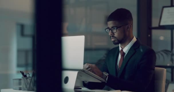 4k video footage of a young businessman looking frustrated while using a laptop during a late night at work. - Filmmaterial, Video
