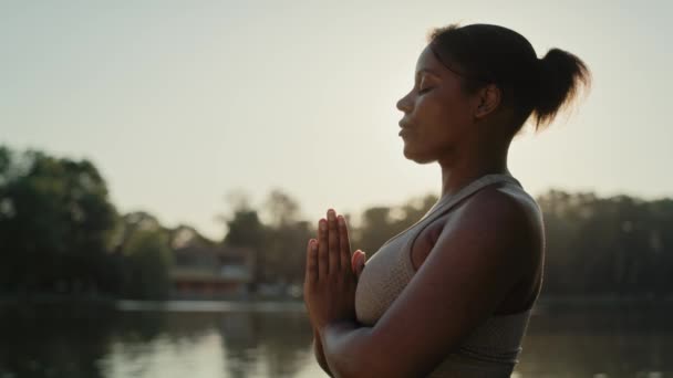 Αφρο-Αμερικανίδα που ασκεί την άσκηση αναπνοής στο πάρκο  - Πλάνα, βίντεο