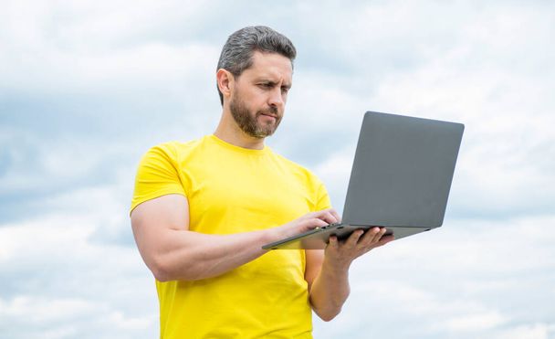 man working online on laptop on sky background. business online. - Фото, зображення