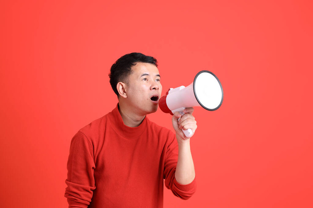 De Aziatische LGBTQ man met rood shirt op de oranje achtergrond. - Foto, afbeelding