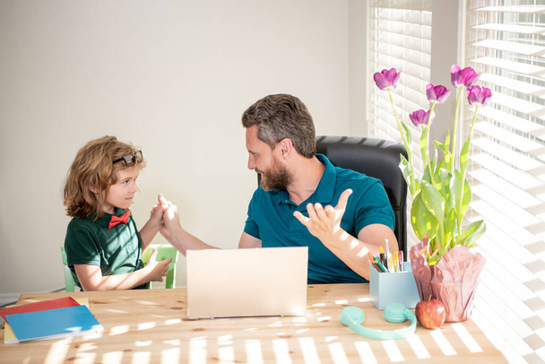 Meglepett apa és fia számítógépet használnak otthon. családi és szülői blog. A fiú házit csinál magántanárral. webinar videó lecke. online oktatás laptopon. Otthonról tanulok. Vissza az iskolába.. - Fotó, kép