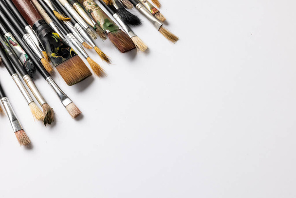Image of composition of diverse brushes on white surface with copy space. School equipment, tools, learning and creativity concept. - Foto, immagini