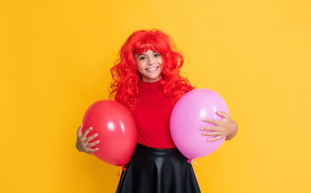 cheerful teen child with party balloon on yellow background. - Fotoğraf, Görsel