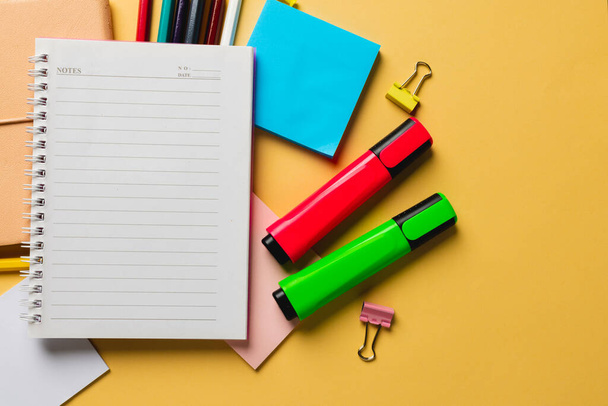 Composition of notebook with copy space and school equipment on yellow surface. School equipment, tools and creativity concept. - Foto, Imagem