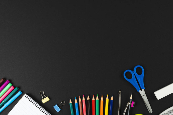 Composition of colorful crayons and school items on black surface with copy space. School equipment, drawing tools, pattern and creativity concept. - Fotografie, Obrázek