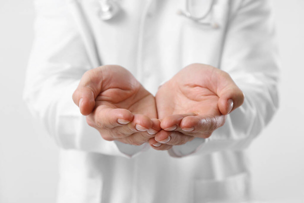 Doctor holding something on white background, closeup - Photo, Image