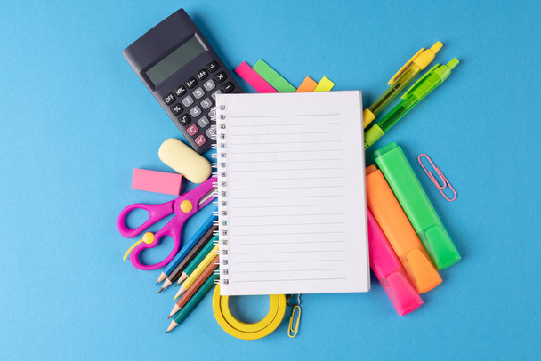 Image of various office supplies, pens and notebook on blue background. Education, learning and creativity. - Photo, image