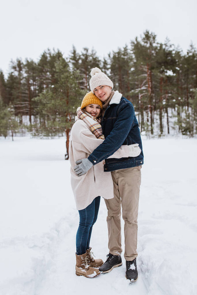 people, love and leisure concept - happy smiling couple hugging in winter park - Photo, Image