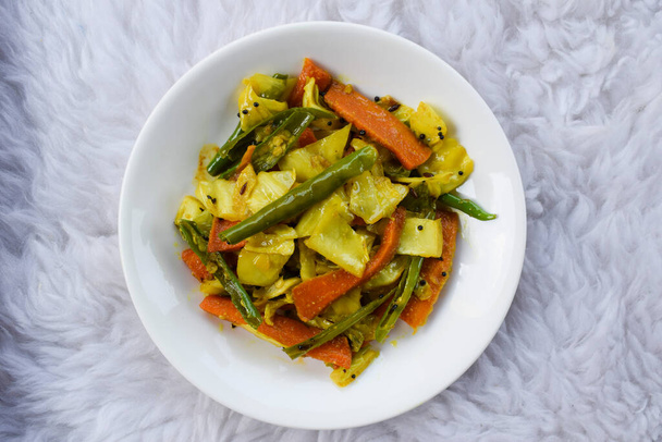 Tasty and healthy Cabbage recipe dish. Indian curry. Gujarati dish called Gobi marcha no Sambharo . mix of sabji and pickle. with Carrots, whole green chillies - Foto, Imagen
