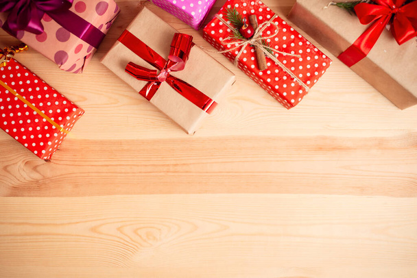 Рождественские подарки на деревянном фоне стола. Теплые цвета, пространство для копирования. - Фото, изображение