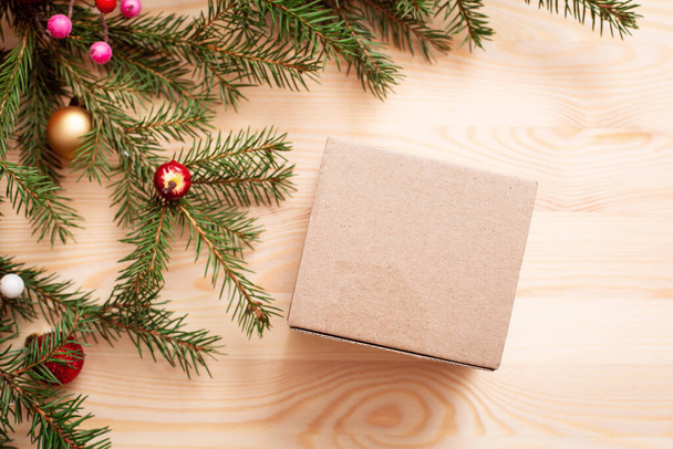 Unwrapped box on wooden table, copy space. Branches of chriatmas tree in the corner of the picture, decoration, top view, flat lay. - Fotografie, Obrázek