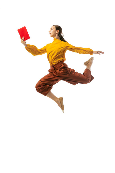 Energetic young girl jumping, flying isolated on white background. Business, start-up, working open-space, ballet or professional occupation concept. Dynamic, fast paced life. Copy space for ad - Foto, afbeelding