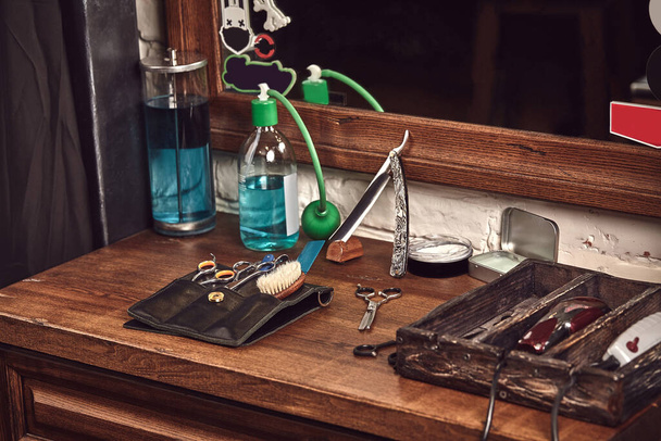 Narzędzia fryzjerskie na drewnianym brązowym stole. Akcesoria do golenia i strzyżenia na stole. Martwa natura - Zdjęcie, obraz