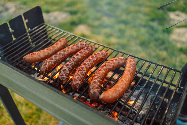 Grilling sausages on barbecue grill. Selective focus.  - Zdjęcie, obraz