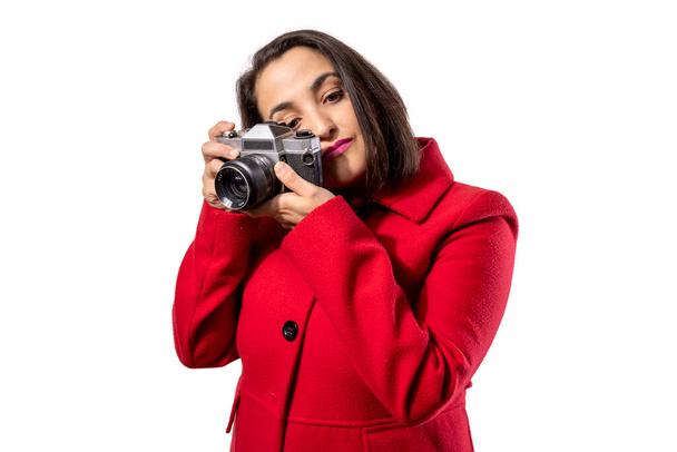 Dziewczyna w czerwonym płaszczu używająca antycznej kamery. Fotografia koncepcyjna. - Zdjęcie, obraz