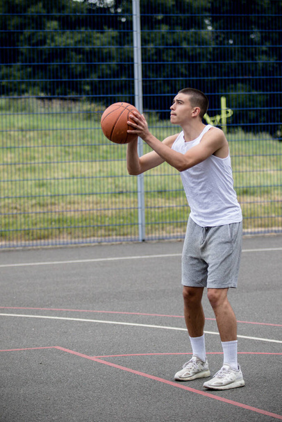 A Nineteen Year Old Teenage Boy Shooting A Hoop in A Basketball Court in A Public Park - Valokuva, kuva