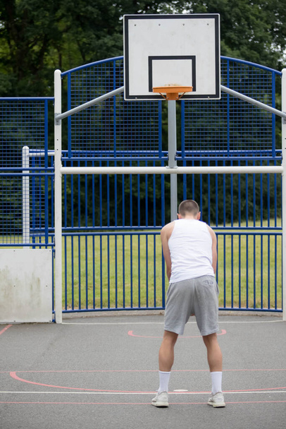 A Nineteen Year Old Teenage Boy Shooting A Hoop in A Basketball Court in A Public Park - Foto, Imagen