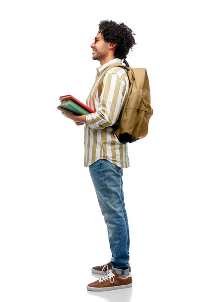 people and education concept - happy smiling man in glasses with backpack and books over white background - Foto, immagini