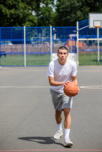 A Nineteen Year Old Teenage Boy Playing Basketball in A Public Park - Foto, immagini