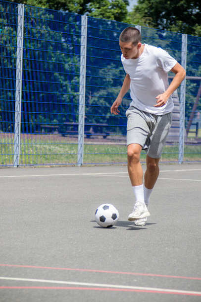 A Nineteen Year Old Teenage Boy Playing Football in A Public Park - Foto, imagen