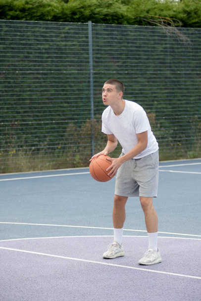 A Nineteen Year Old Teenage Boy Playing Basketball in A Public Park - Foto, Bild
