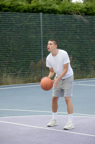 A Nineteen Year Old Teenage Boy Playing Basketball in A Public Park - Foto, Imagem