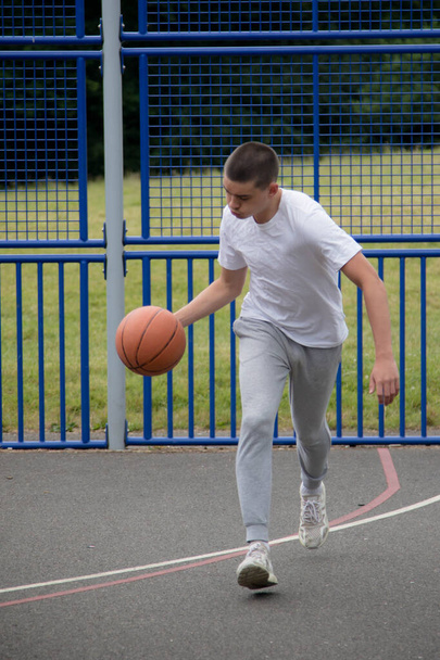 A Nineteen Year Old Teenage Boy Playing Basketball in A Public Park - Foto, afbeelding