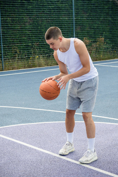 A Nineteen Year Old Teenage Boy Shooting A Hoop in A Basketball Court in A Public Park - Fotó, kép