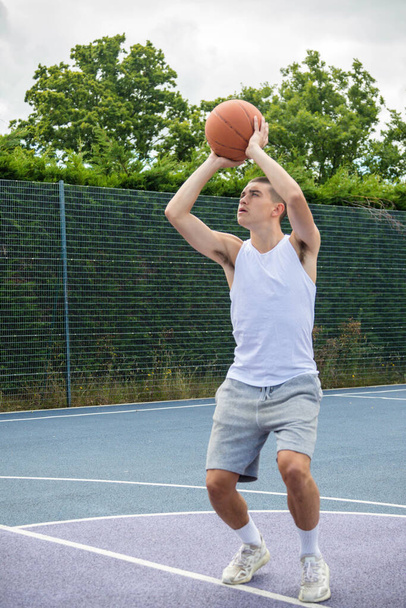 A Nineteen Year Old Teenage Boy Shooting A Hoop in A Basketball Court in A Public Park - Photo, image