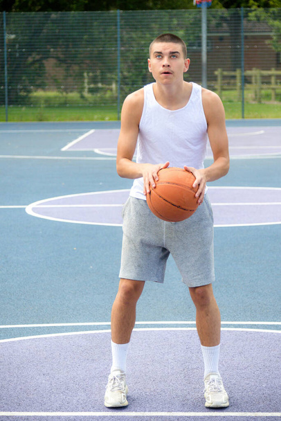 A Nineteen Year Old Teenage Boy Playing Basketball in A Public Park - Φωτογραφία, εικόνα