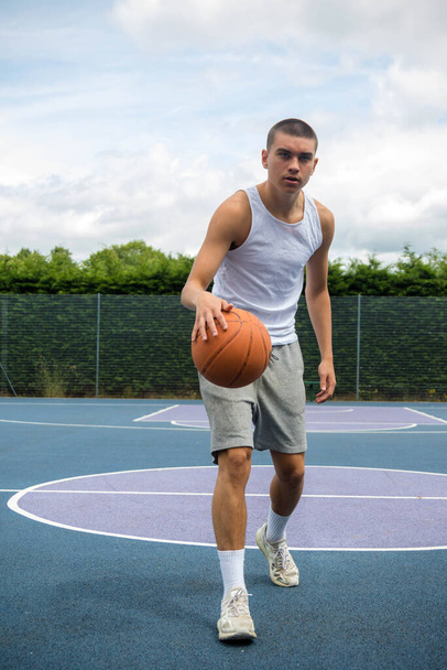 A Nineteen Year Old Teenage Boy Playing Basketball in A Public Park - Foto, Imagen