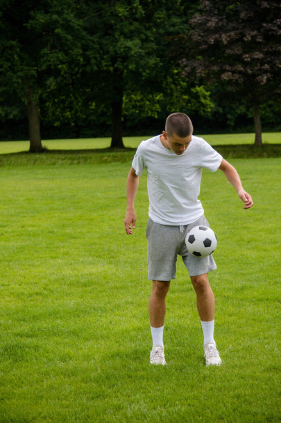 A Nineteen Year Old Teenage Boy Playing Football in A Public Park - Фото, зображення