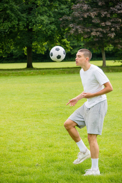 A Nineteen Year Old Teenage Boy Playing Football in A Public Park - Foto, Bild