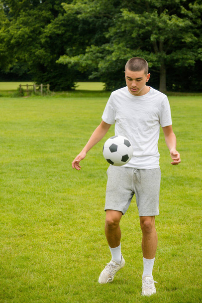 A Nineteen Year Old Teenage Boy Playing Football in A Public Park - Foto, Bild