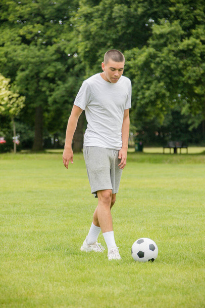 A Nineteen Year Old Teenage Boy Playing Football in A Public Park - Photo, image