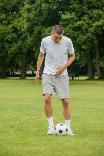 A Nineteen Year Old Teenage Boy Playing Football in A Public Park - Foto, immagini