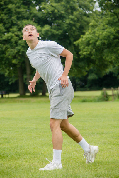 A Nineteen Year Old Teenage Boy Playing Football in A Public Park - Foto, Imagen
