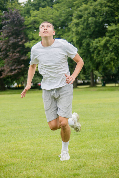 A Nineteen Year Old Teenage Boy Playing Football in A Public Park - Фото, зображення