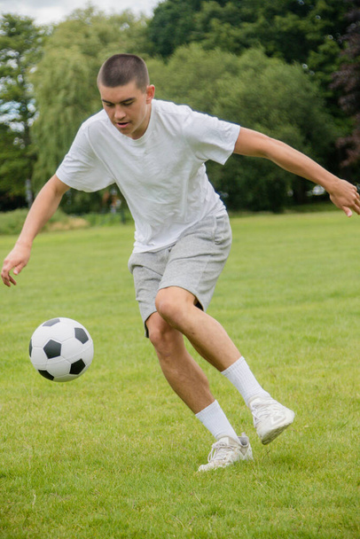 A Nineteen Year Old Teenage Boy Playing Football in A Public Park - Φωτογραφία, εικόνα