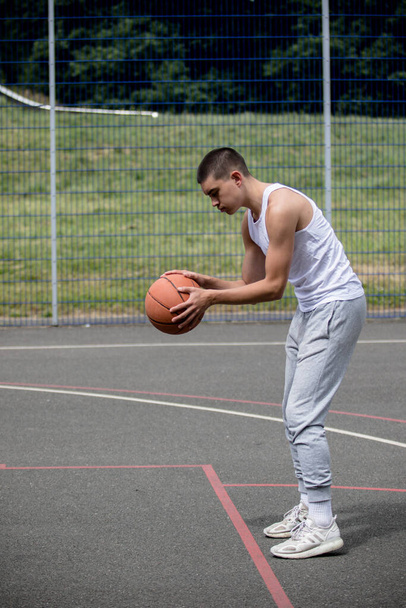 A Nineteen Year Old Teenage Boy Shooting A Hoop in A Basketball Court in A Public Park - Фото, зображення