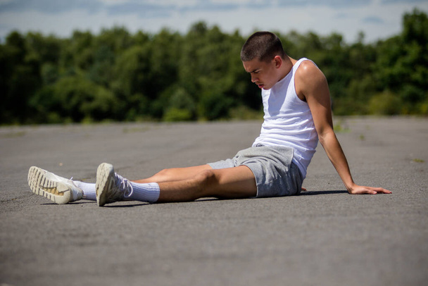 A Nineteen Year Old Teenage Boy Doing Situps In A Public Park - 写真・画像