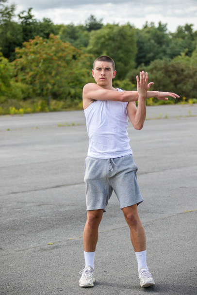 A Nineteen Year Old Teenage Boy Stretching In A Public Park - Fotoğraf, Görsel
