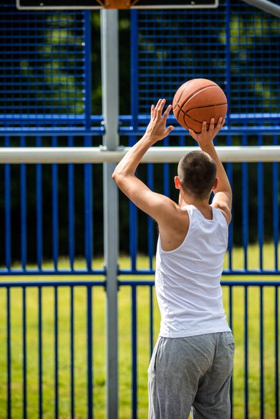 A Nineteen Year Old Teenage Boy Shooting A Hoop in A Basketball Court in A Public Park - Fotó, kép