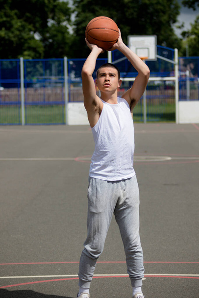 A Nineteen Year Old Teenage Boy Shooting A Hoop in A Basketball Court in A Public Park - Foto, afbeelding
