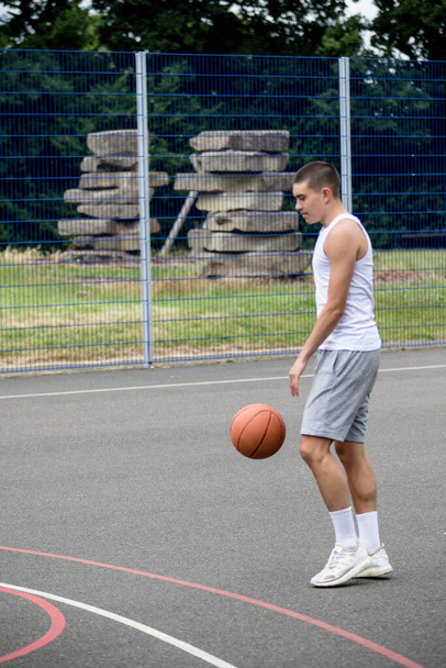 A Nineteen Year Old Teenage Boy Playing Basketball in A Public Park - Valokuva, kuva
