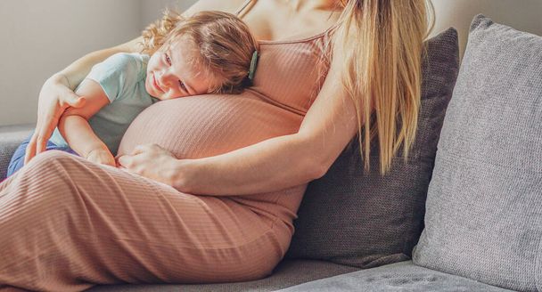 Pieni vauva tyttö rentouttava äidin raskaana vatsa - raskaana äiti lapsi - Perhekonsepti - Valokuva, kuva