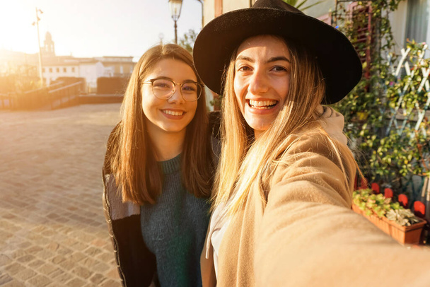 Les adolescents prennent selfie au coucher du soleil - Les filles sourient à la caméra et s'amusent - Photo, image