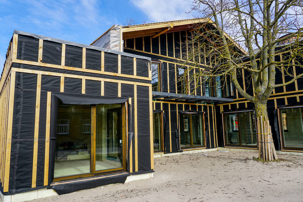une simple maison privée moderne de deux étages en bois en construction, fond bleu ciel - Photo, image