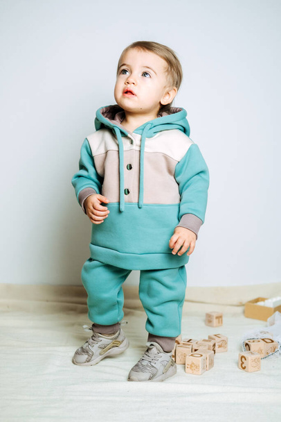 Unisex clothes for babies. Cute baby in cotton set suit on light background. Kids fashion. - Photo, Image