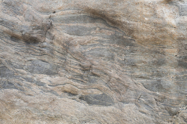 Side view of a rocky surface showing various strata and rough texture - Foto, imagen